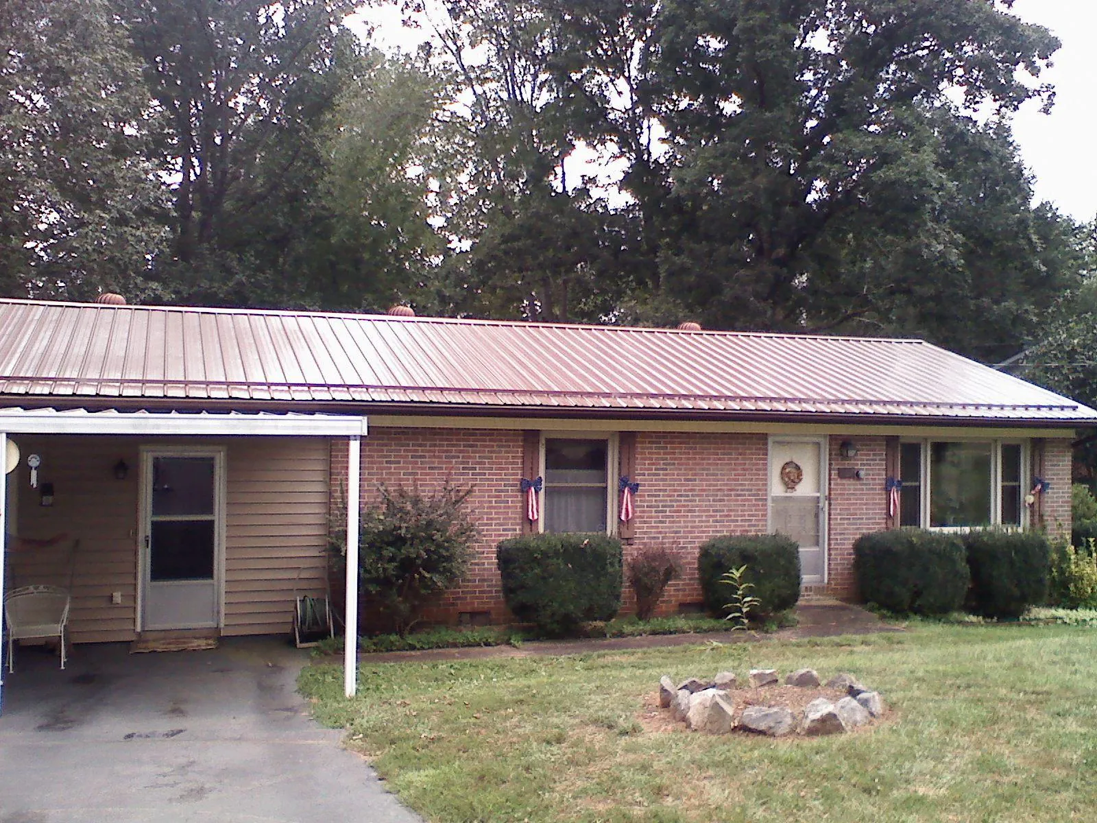 Bronze metal roof and carport on a brick ranch home — Roof Repair work by our crew in Deerfield Beach